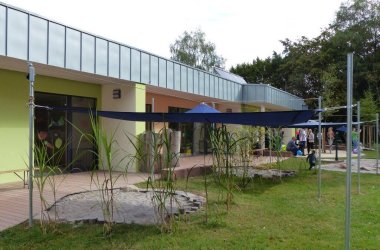 Kitagebäude, im Hintergrund sind Eltern, welche sich unterhalten