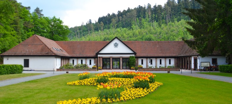 Waldfriedhof Außengebäude Zu sehen ist die Rückseite der Aussegnungshalle am Waldfriedhof mit dem davor angelegten Blumenbeet mit Frühjahrsflor
