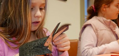 Ledertiere basteln im Stadtmuseum Altes Rathaus Mädchen schneidet etwas aus und bastelt Ledertiere im Stadtmuseum Altes Rathaus