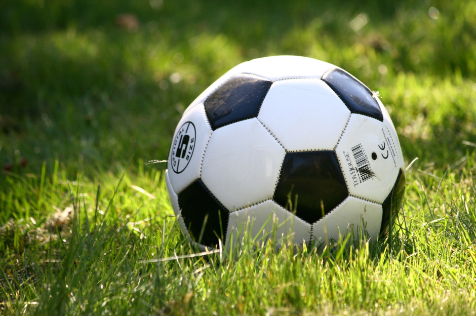 Fußball auf Rasen Zu sehen ist ein Fußball auf einem Rasen