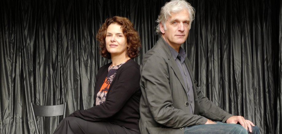 Mit Barbara Auer und Walter Sittler sind am 18. September 2026 zwei bekannte TV-Gesichter zu Gast in Pirmasens. Auf Einladung der Stadtbücherei präsentiere sie in der Festhalle eine szenische Lesung aus dem Roman „Unsere Seelen bei Nacht“. Zwei Personen sitzen Rücken an Rücken auf einer Bühne vor einem dunklen Vorhang und blicken selbstbewusst in die Kamera – eine Szene mit theaterähnlicher Inszenierung.