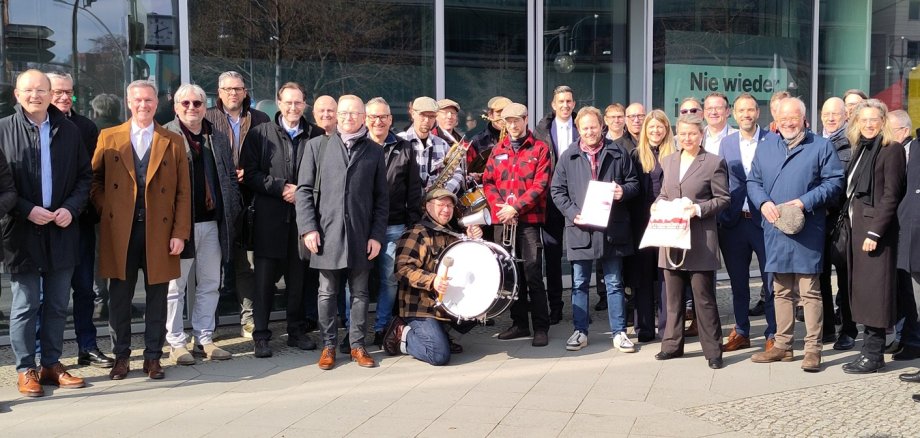 Bürgermeister und Kämmerer mit der Band „It's live“ vor dem Konrad-Adenauer-Haus.
Der Pirmasenser Bürgermeister Michael Maas übergibt in Berlin den Forderungskatalog der Bündnis-Kommunen an den CDU-Bundestagsabgeordneten Florian Bilic. Bürgermeister und Kämmerer mit der Band „It's live“ vor dem Konrad-Adenauer-Haus.
Der Pirmasenser Bürgermeister Michael Maas übergibt in Berlin den Forderungskatalog der Bündnis-Kommunen an den CDU-Bundestagsabgeordneten Florian Bilic.