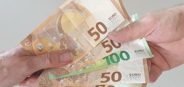 Antikorruption Eine Hand hat viele Geldscheine, andere Hand nimmt diese