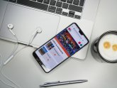 Notebook mit Handy auf dem die Website PS aufgerufen ist Notebook mit Handy auf dem die Website PS aufgerufen ist
