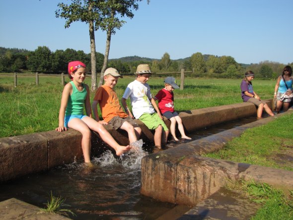 Barfußpfad Barfußpfad vier Kinder haben Füße im Wasser