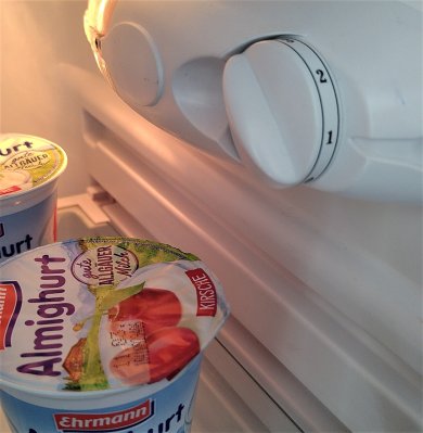Energie Kühlschrank von Innen in Nahaufnahme mit leuchtendem Licht und 2 Bechern Joghurt